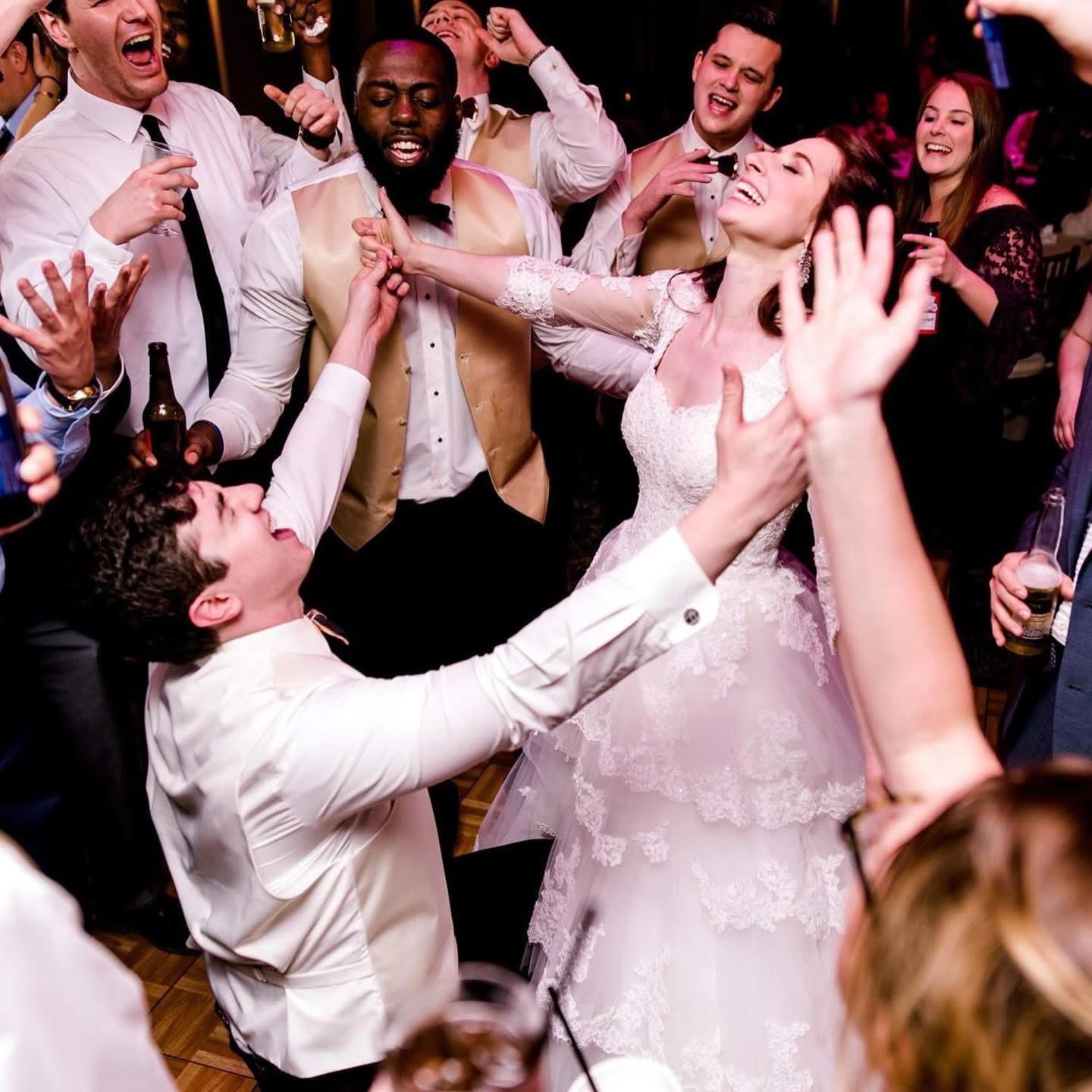 Bride and guests celebrating together on a packed dance floor